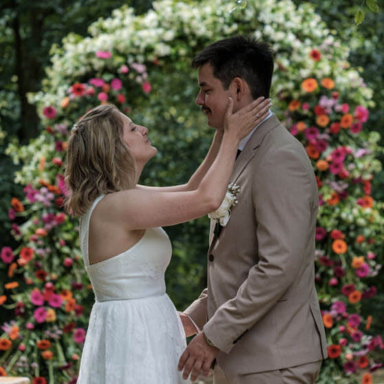 Brudepar ved blomsterbue