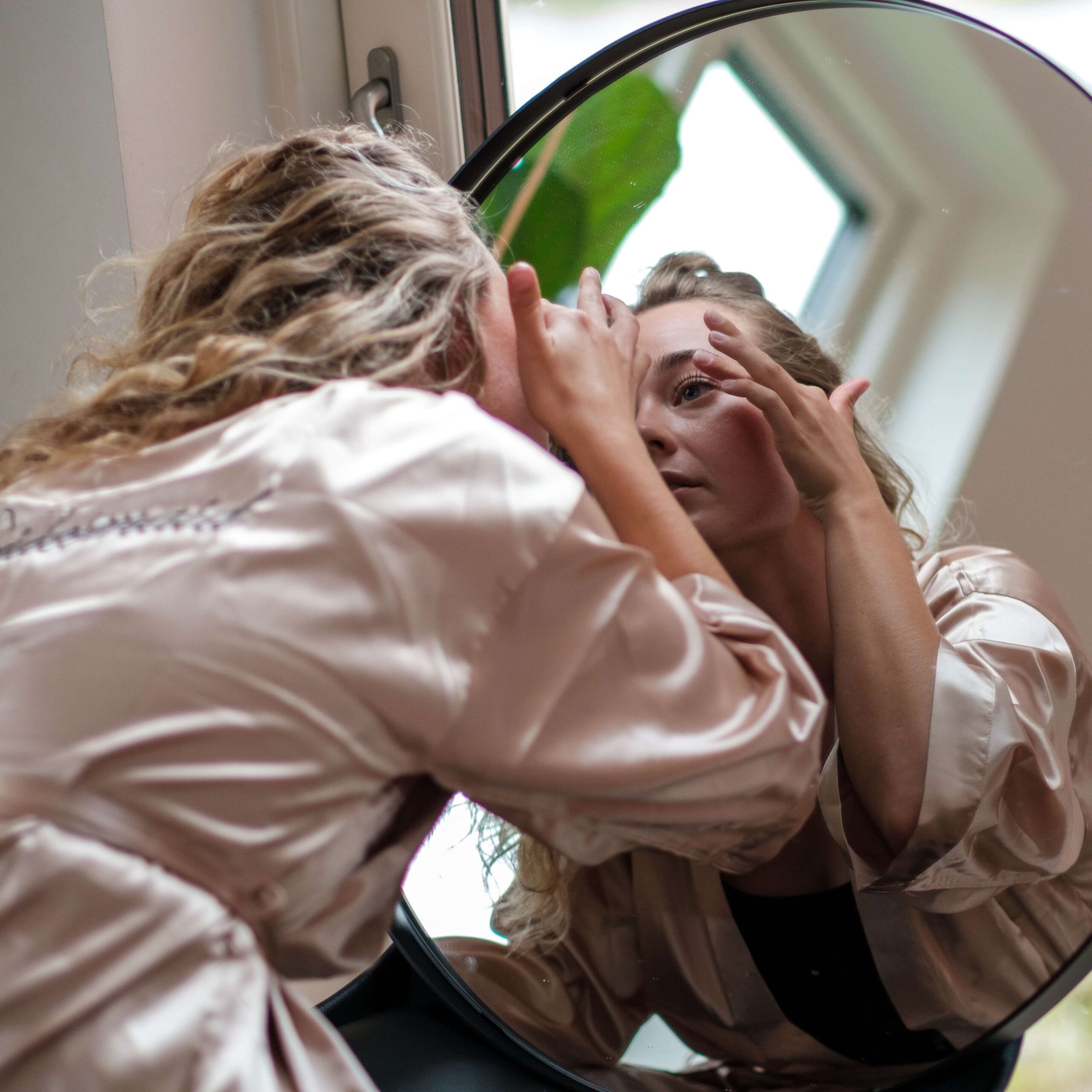 Brudepige lægger makeup i spejl